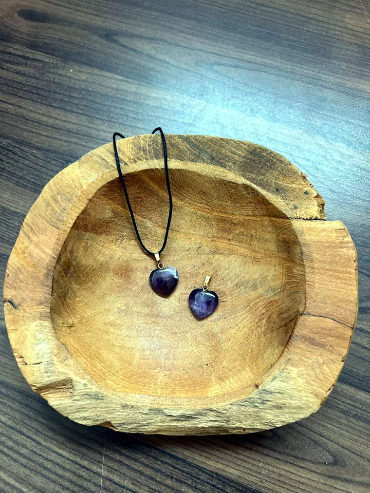 Amethyst Herz Anhänger mit goldener Öse in einer Holzschale