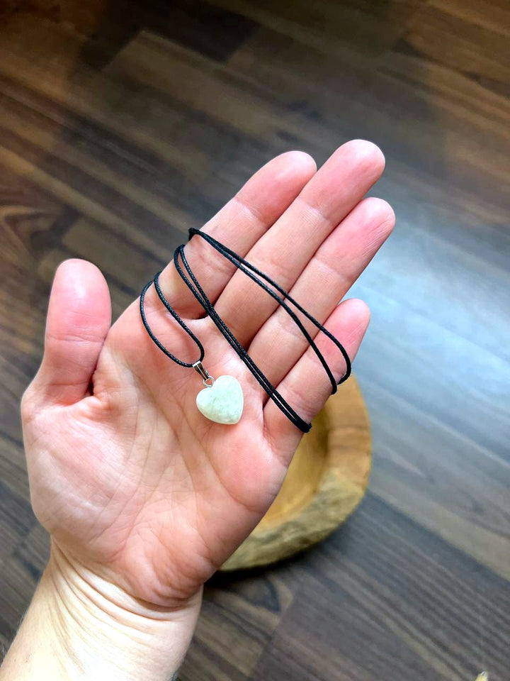 Aquamarin Herz Anhänger mit schwarzem Baumwollband auf der Hand