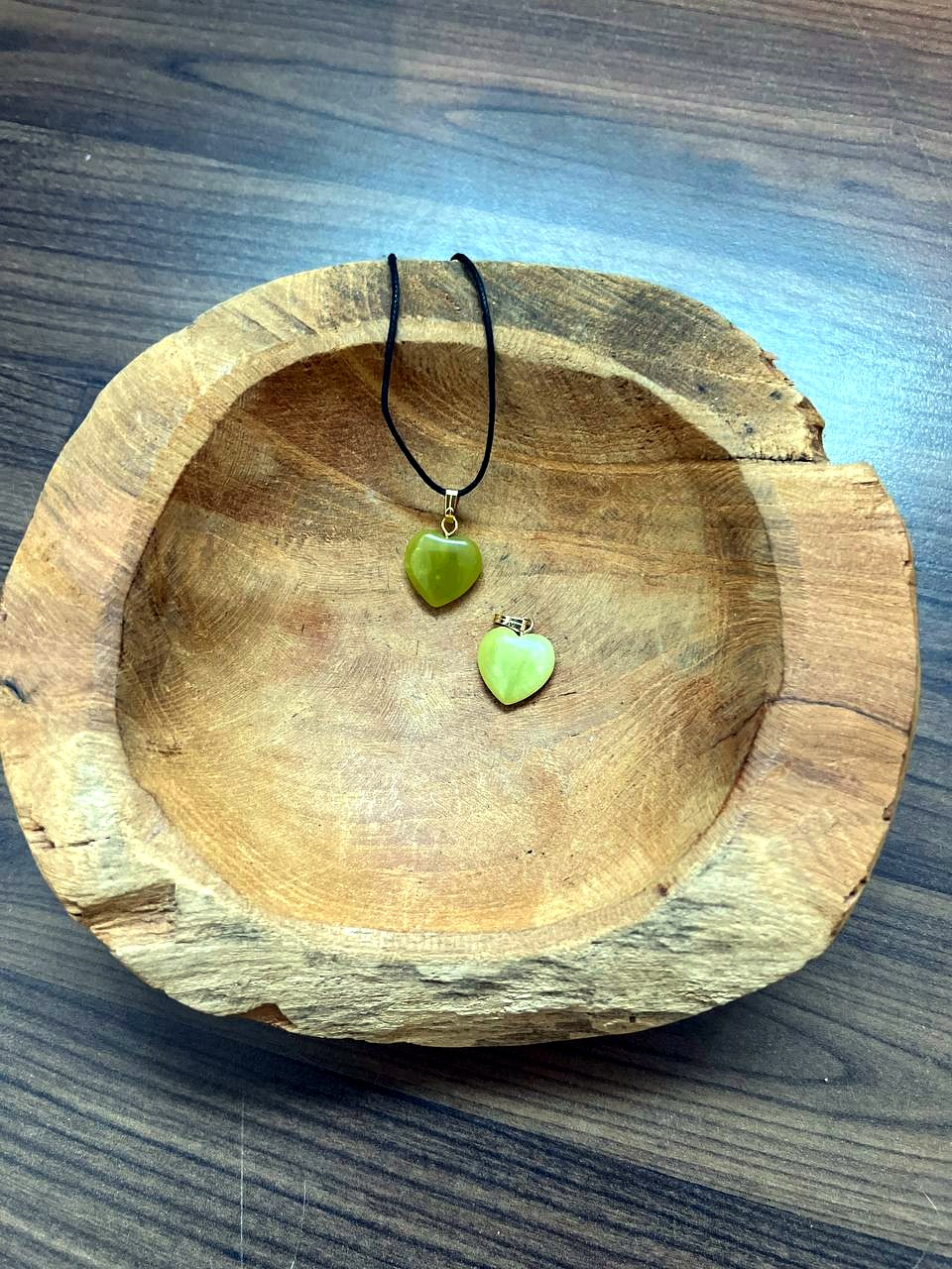 Jade Serpentin Herz Anhänger mit goldener Öse in einer Holzschale