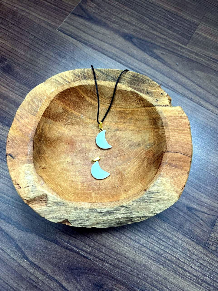 Aquamarin Mond Anhänger mit goldener Öse in einer Holzschale