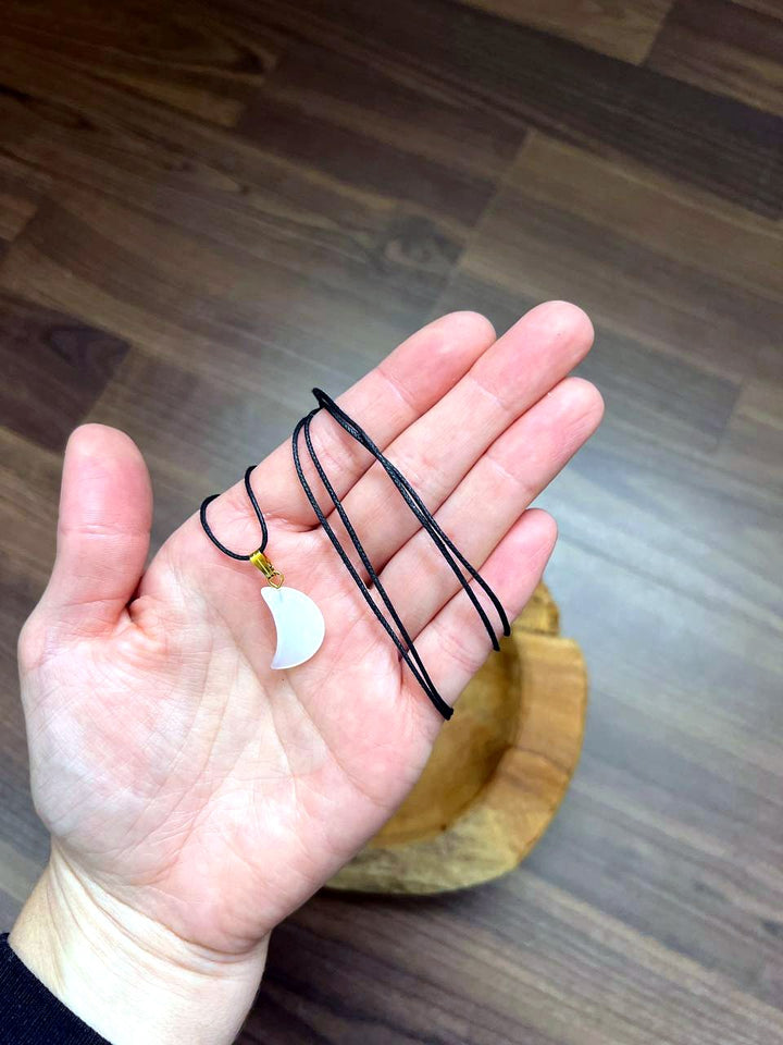 Friedensachat Mond Anhänger mit schwarzem Baumwollband auf der Hand