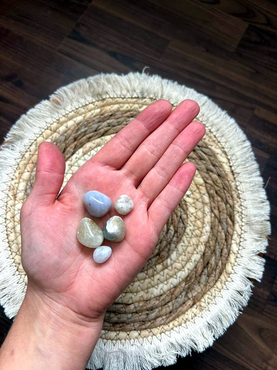 Helle, milchige Trommelsteine auf der Hand
