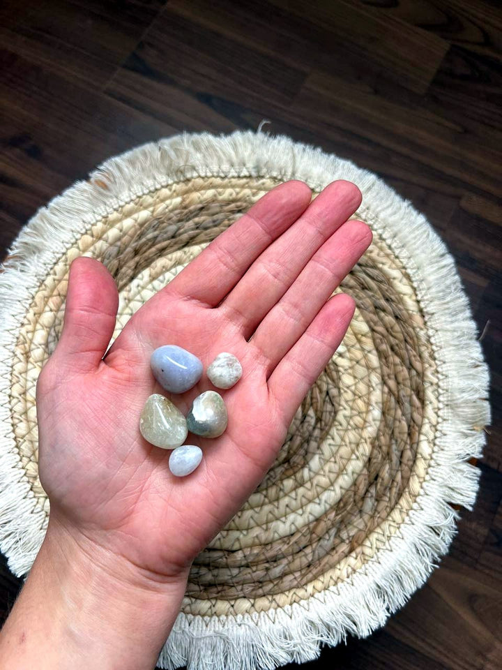 Helle, milchige Trommelsteine auf der Hand