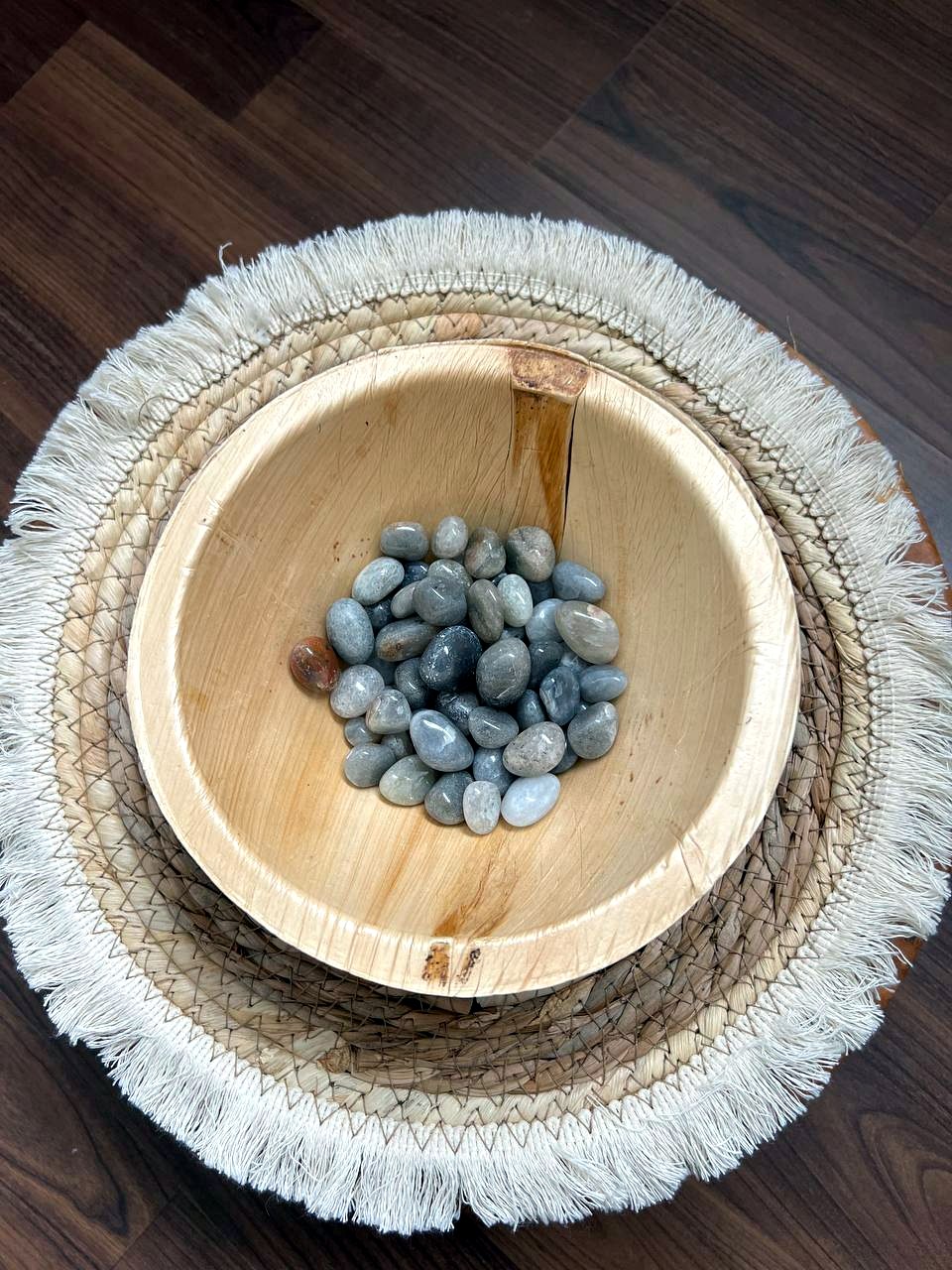 Grau-blaue Trommelsteine in einer Holzschale