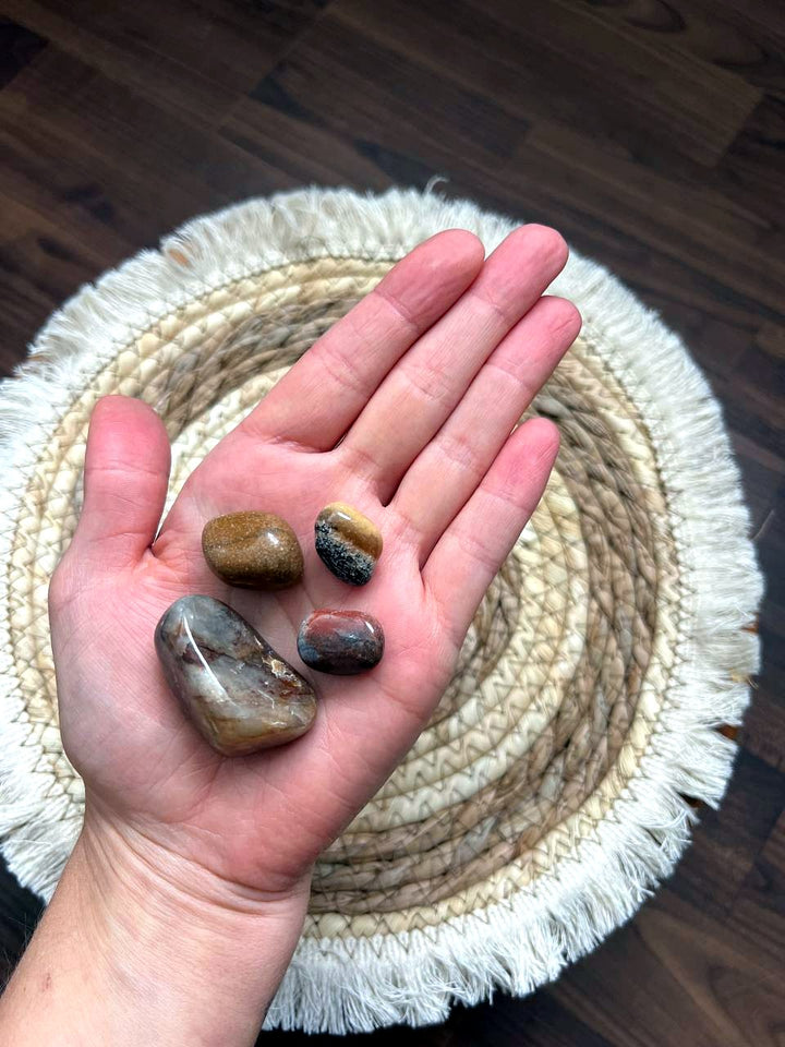 Braune und roséfarbene Trommelsteine auf der Hand